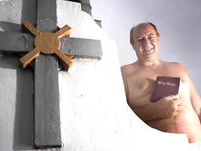 Nude man behind a cross holding a bible